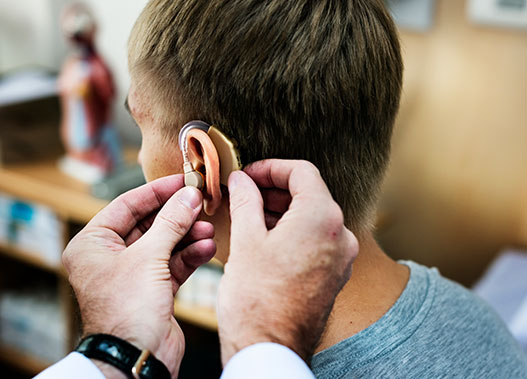 man having hearing aid checked